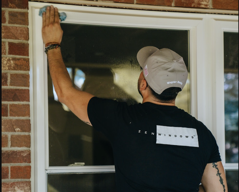A worker from Zen Windows adjusting a window