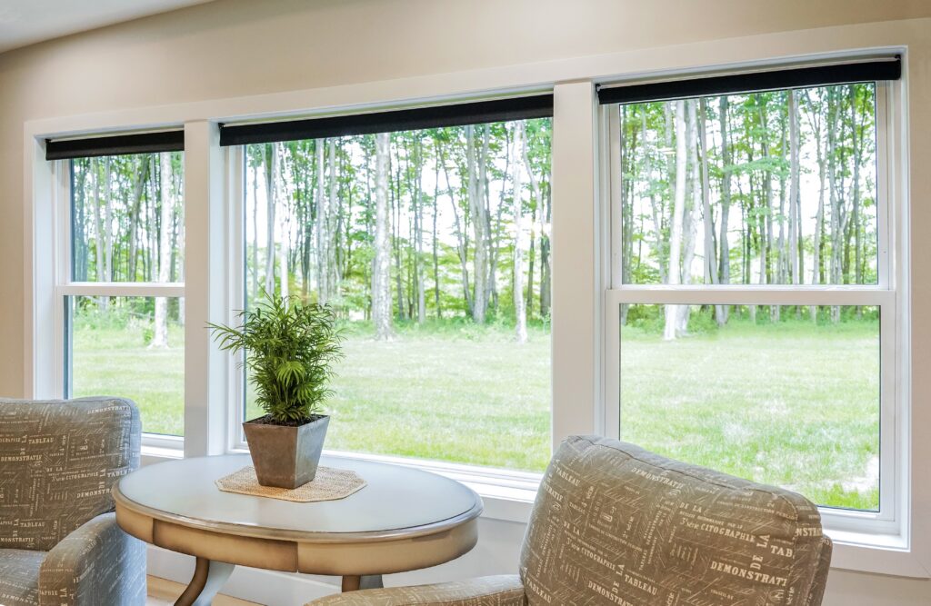 A room with lots of sunlight entering through the large windows.
