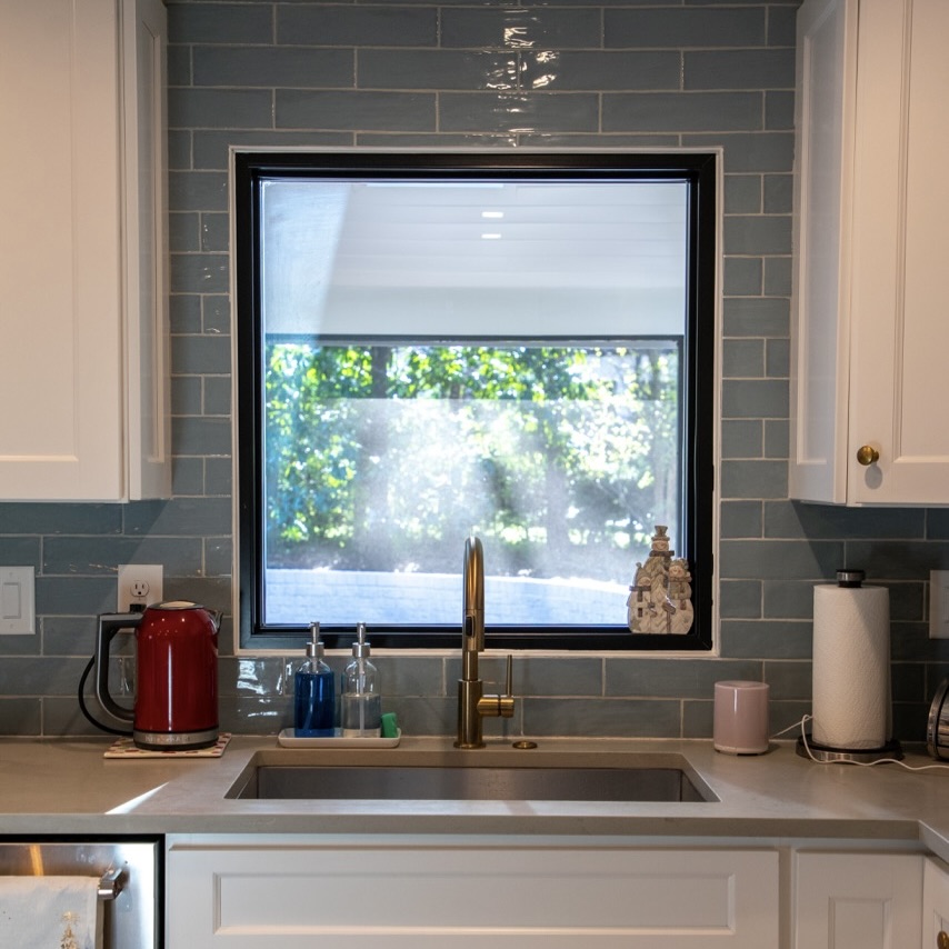 Sunlight coming through picture window over kitchen sink.
