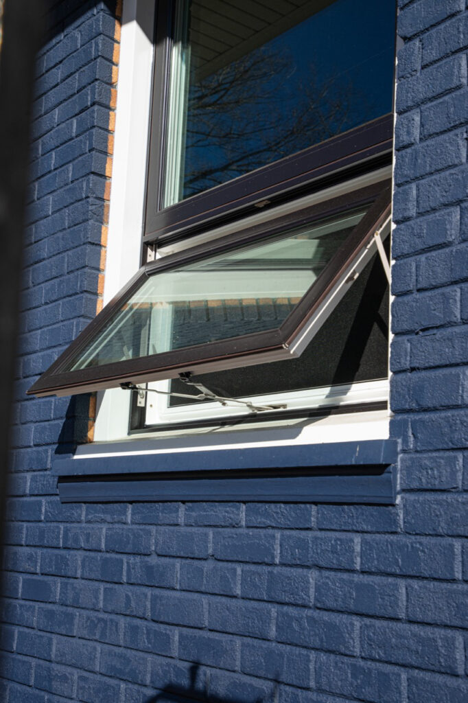 Black awning windows open and shown from the exterior