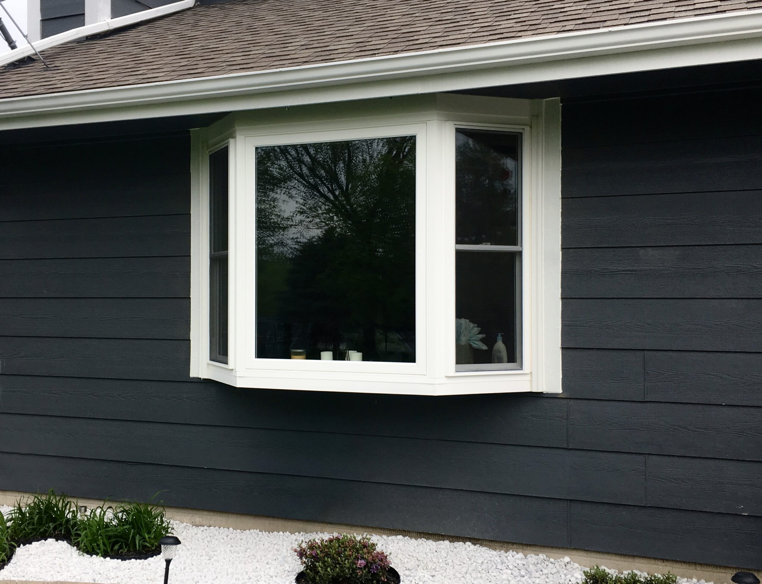 White bay window over white rock garden.