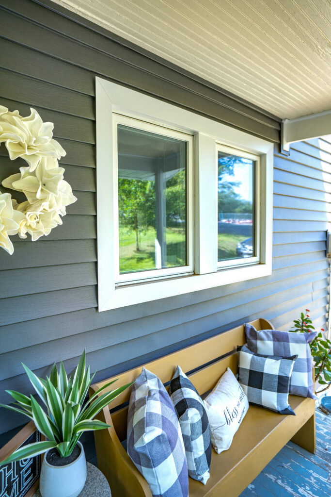 White Endure casement windows with an outdoor bench in front.