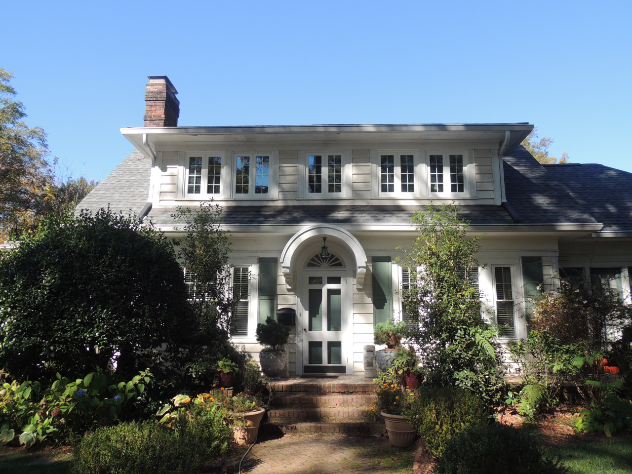 Wide view of house with white casement windows.