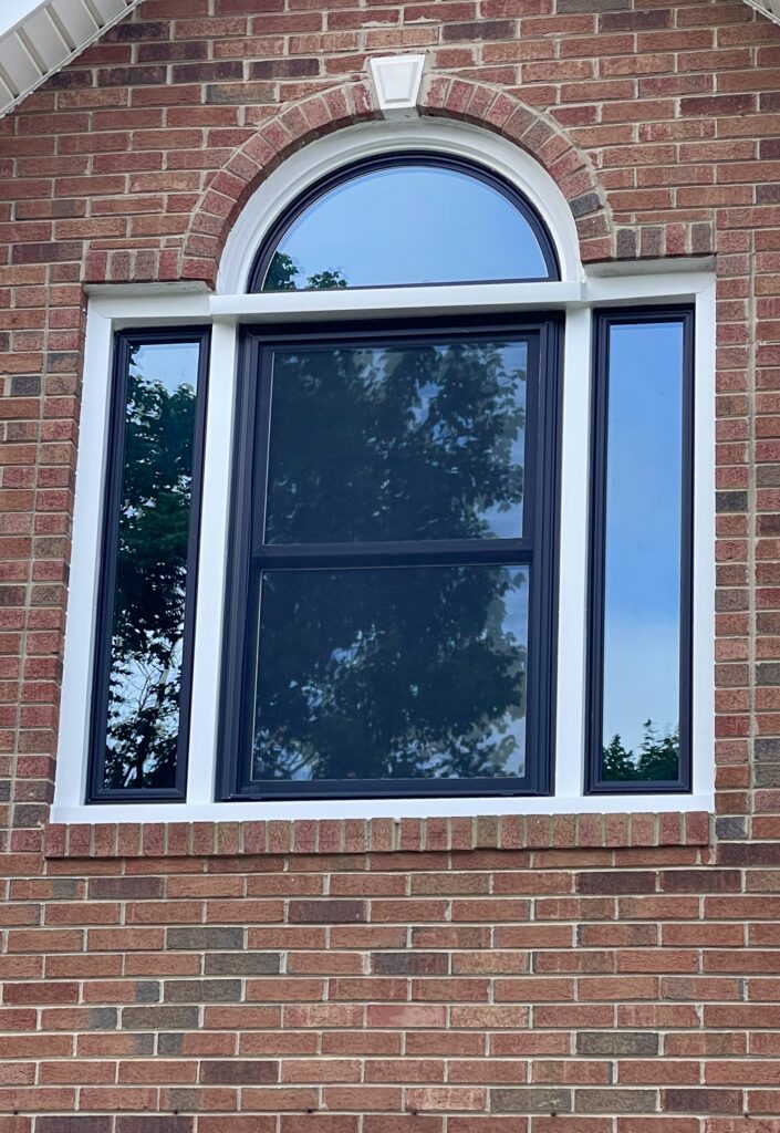 Black double-hung window with round top.