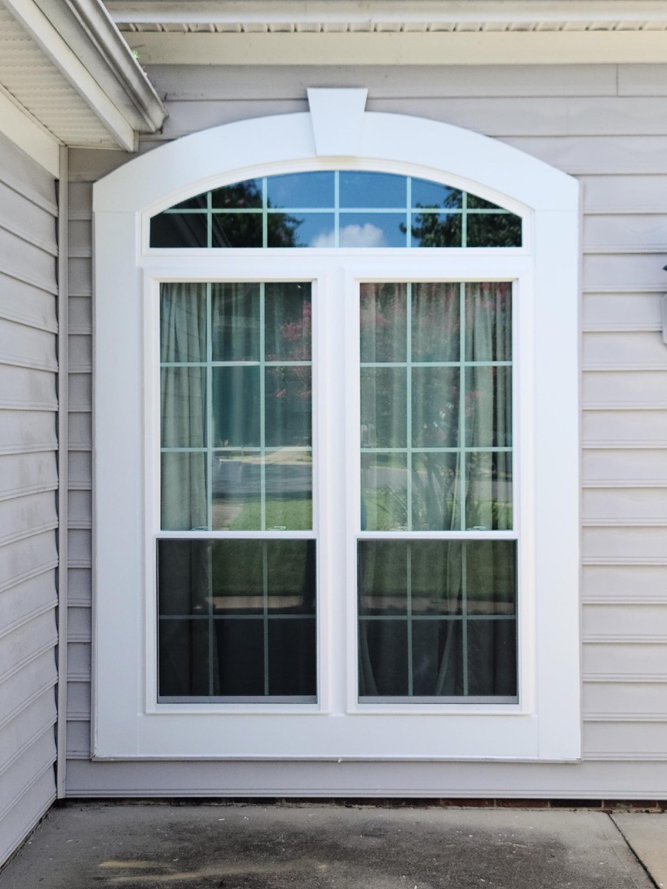 Double-hung windows with round top and grids.