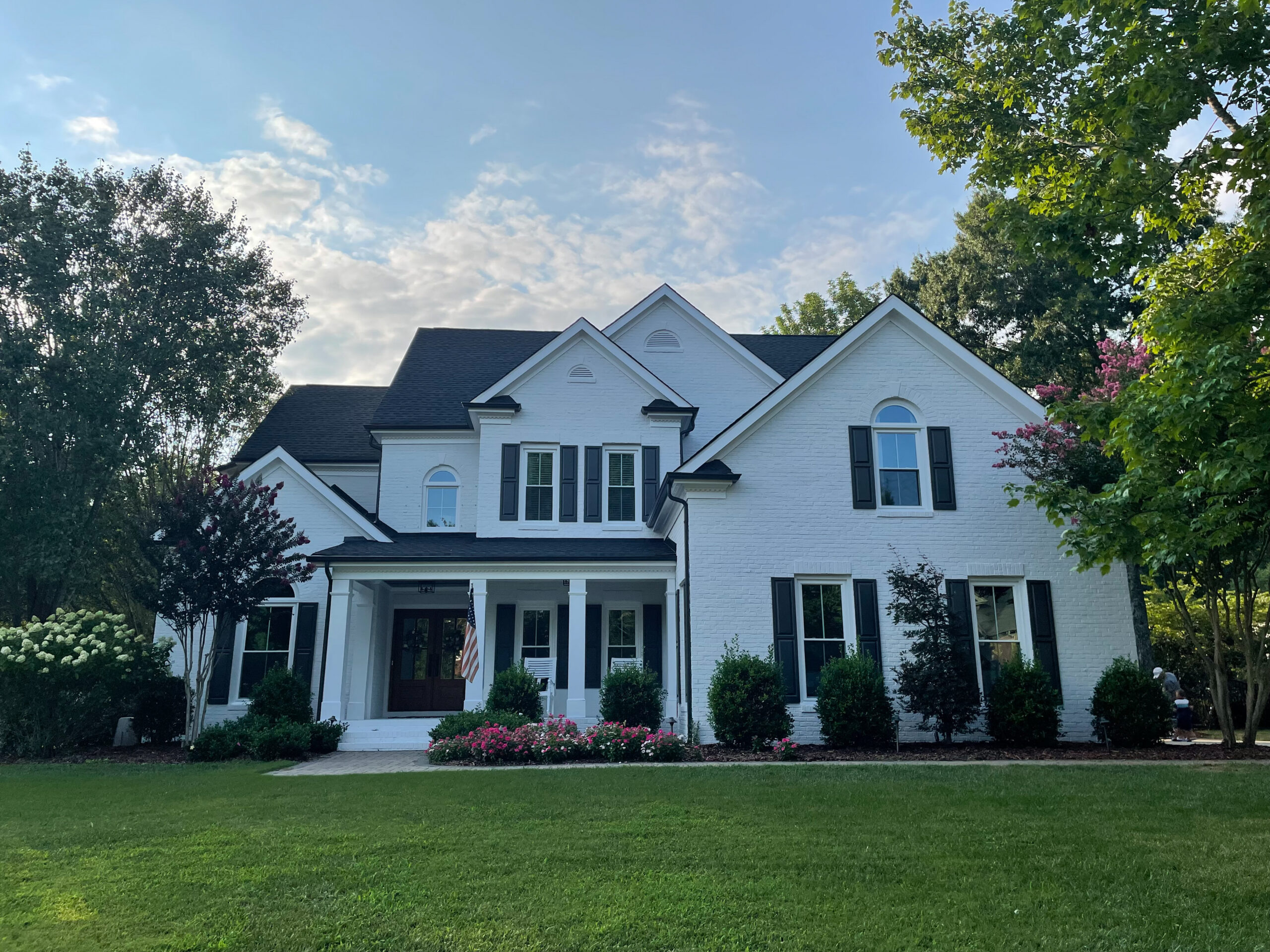 Double-hung windows on white house with black shutters.