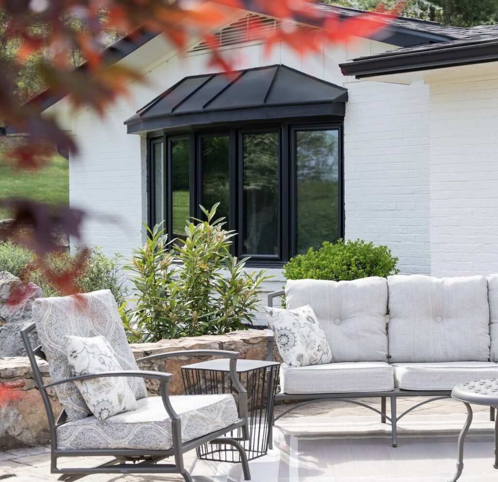 Black Endure bow window behind a patio furniture set.