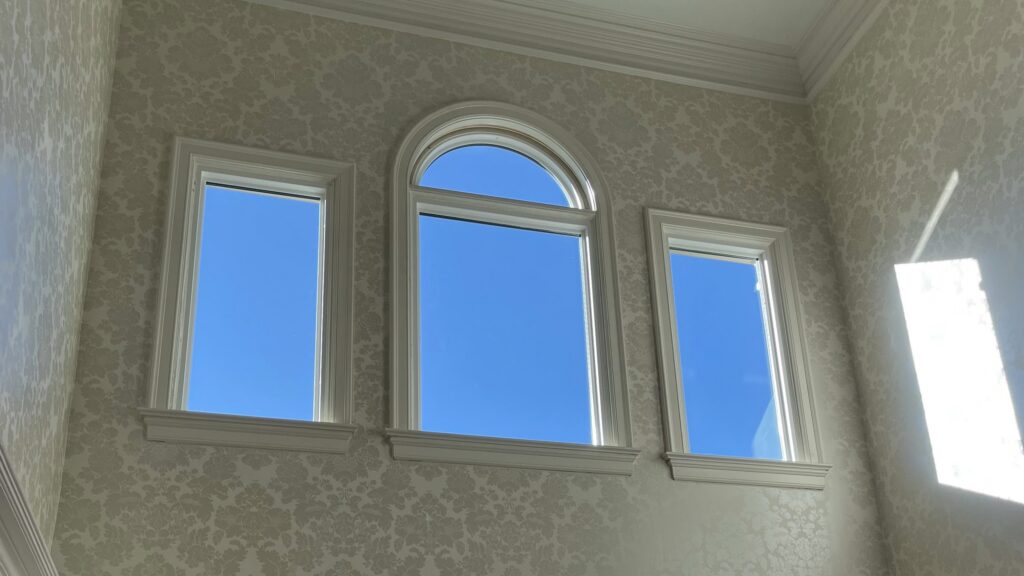 Round top window above three picture windows.