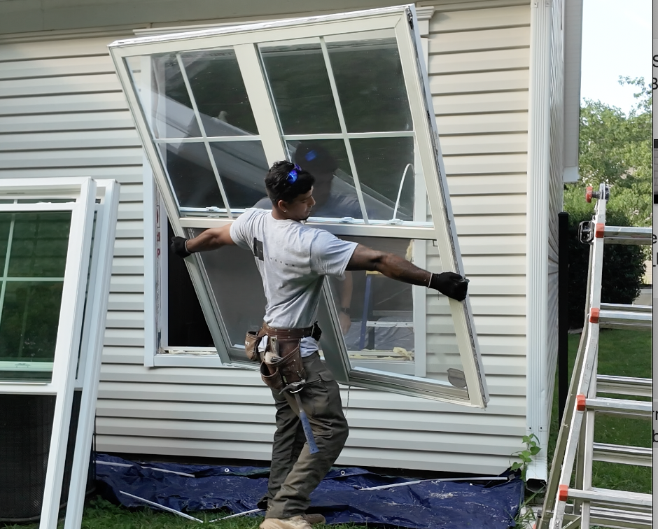 Carrying old double-hung window away from opening.
