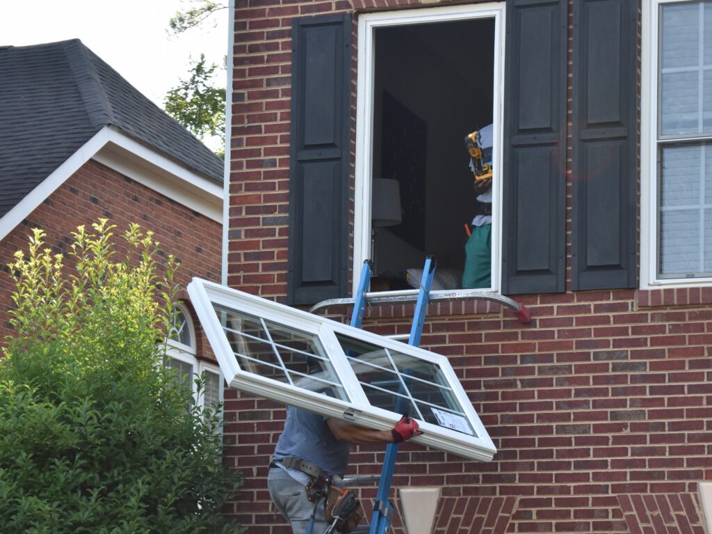 Replacement window being carried to the opening.