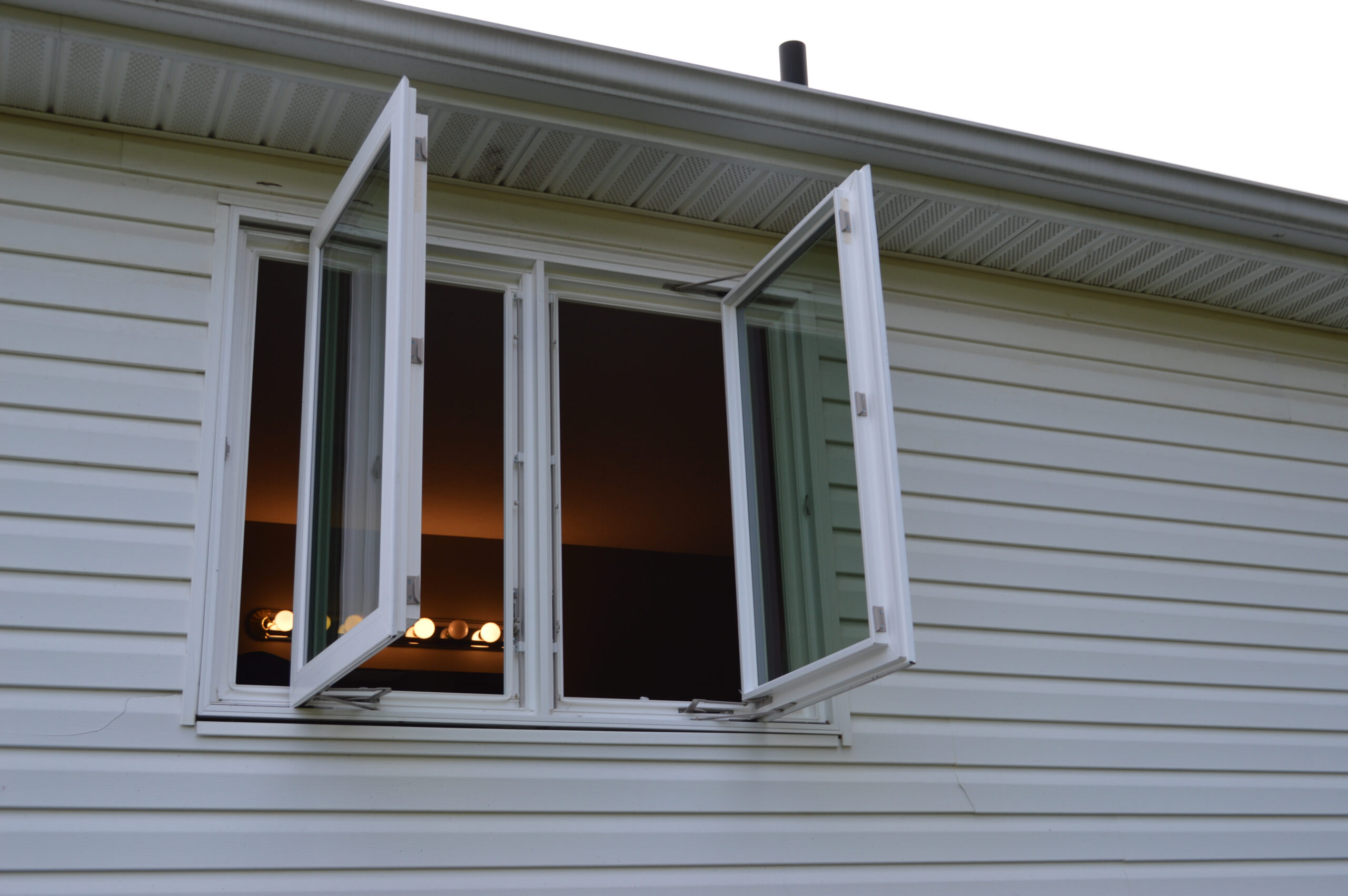 Open white casement window from exterior.