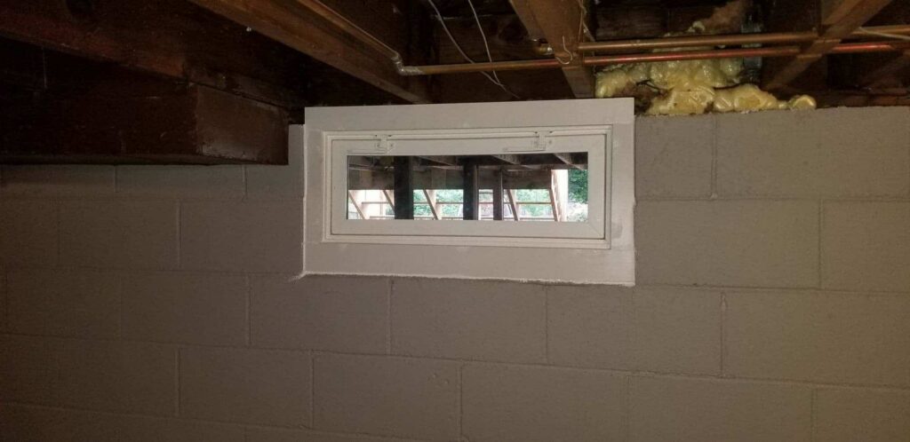 White hopper window in basement.