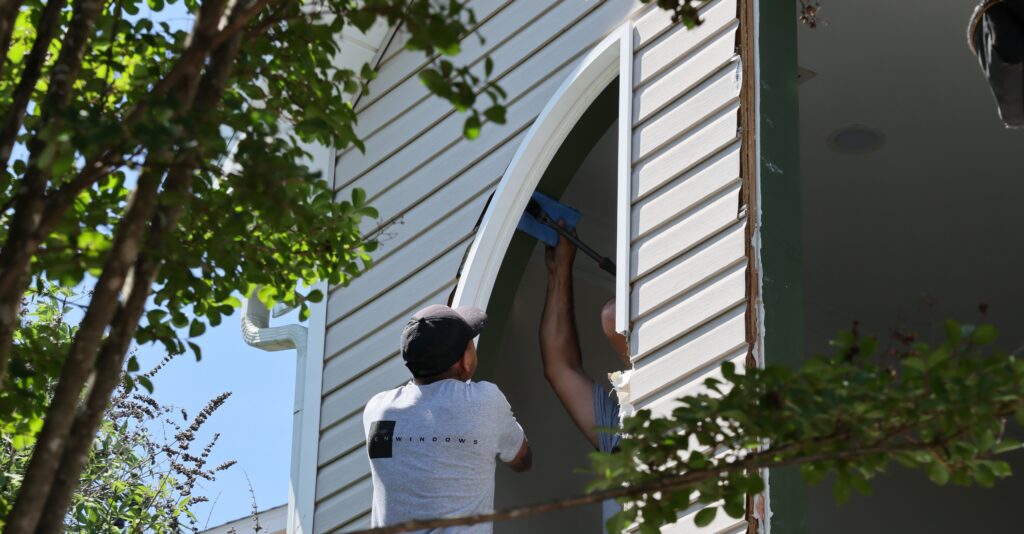 Installers taking out the old frame of a window before installing a new one.