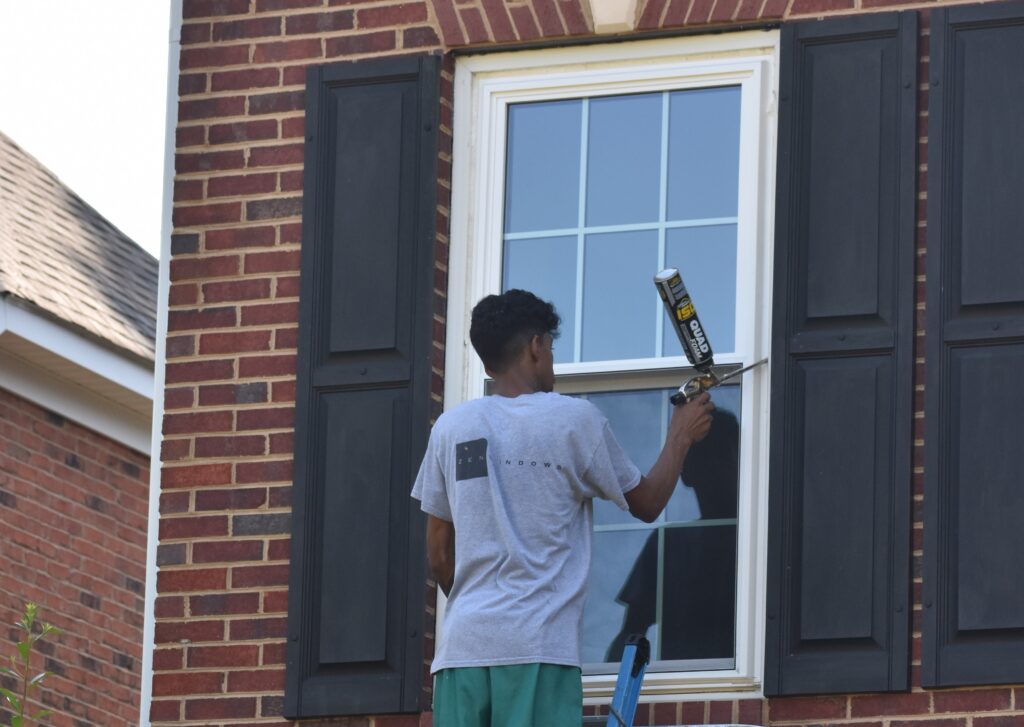 Caulking a window.