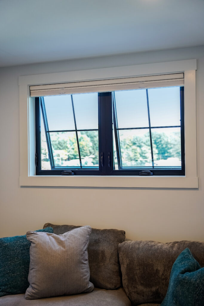 Black awning windows open over couch.